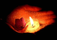 Kerze mit einer Blüte in der Hand